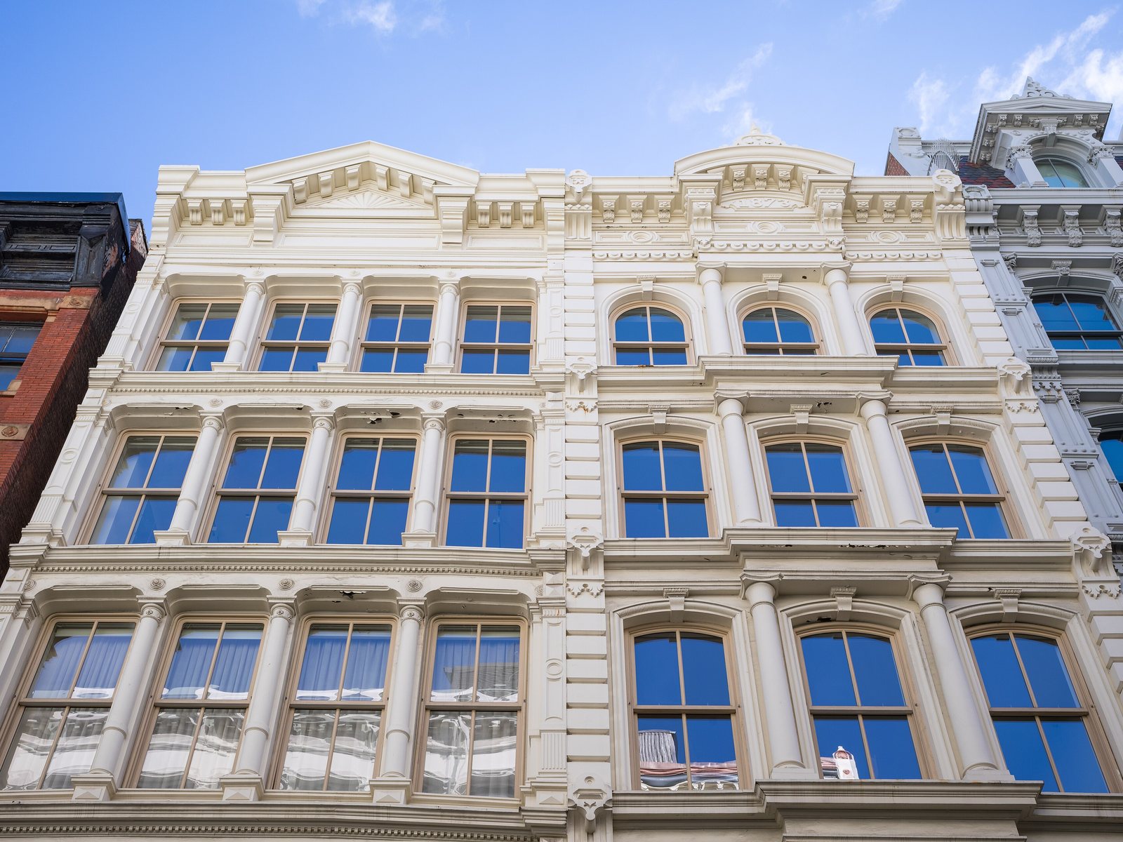 Cast-iron facade of 28 Greene Street in the SoHo–Cast Iron Historic District, Manhattan, with arched windows and Corinthian columns and no people, for a SoHo loft appraisal guide