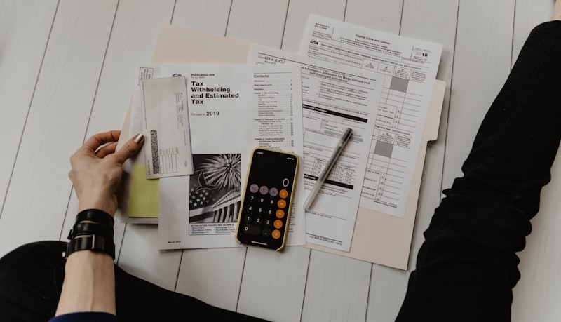 Homeowner reviewing mortgage refinance documents at a desk with a model house beside them